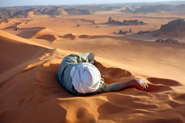 "Zasłużony odpoczynek na Saharze" to kolejne wyróżnione zdjęcie. Przestawia algierskiego przewodnika, który odpoczywa w czasie wspinaczki swoich "podopiecznych" na szczyt Tin-Merzouga.