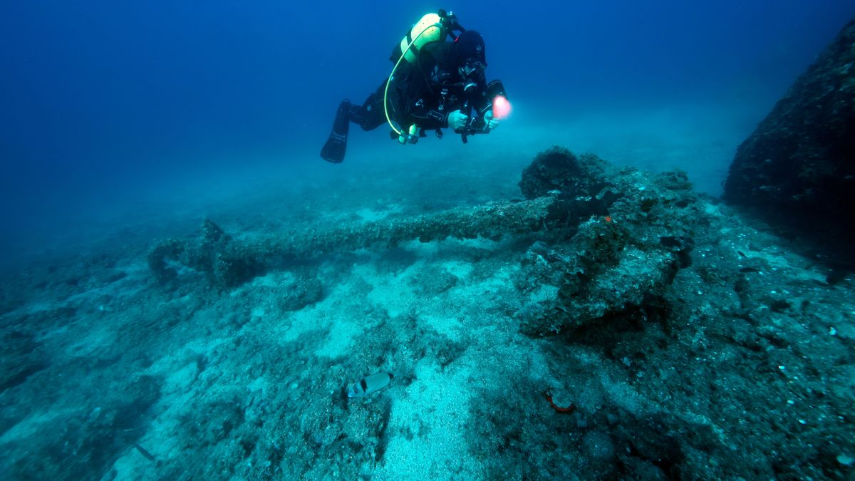 IZMIR, TURKIYE - OCTOBER 20: A scuba diver explores a sunken ship underwater off the coast of Cesme, a prominent diving destination known for its rich marine fauna and flora, tuna farms, ray species, and shipwrecks in Izmir, Turkiye, on October 20, 2025. The area, which attracts many diving enthusiasts every year, is also home to longtail stingrays, a species rarely observed in Turkish waters. The Monem Wreck, suitable for divers of all levels, offers visitors an impressive diving experience with high underwater visibility. Tuna farms, accessible only with special permission, are among the habitats of Mediterranean bluefin tuna. In the blue depths of Cesme, octopuses and other marine creatures also appear before the lenses of diving enthusiasts. (Photo by Tahsin Ceylan/Anadolu via Getty Images)