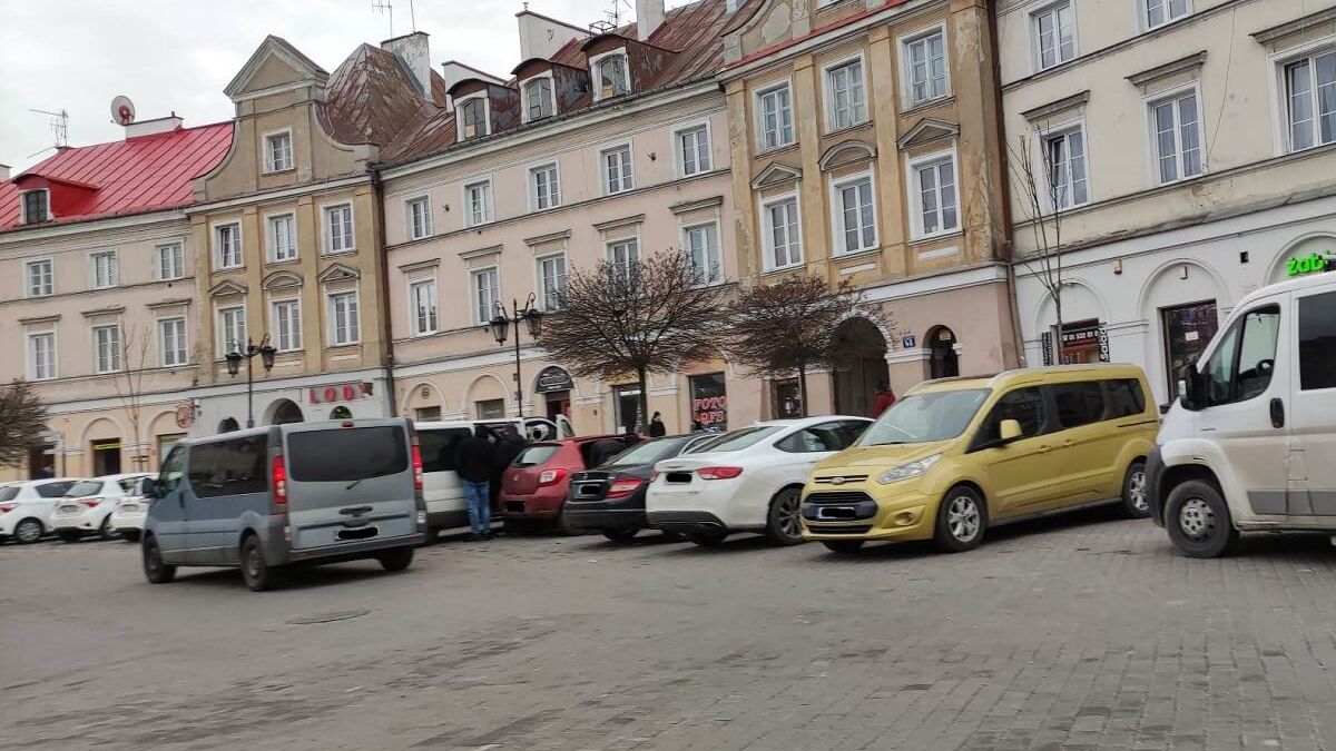 Policyjni wywiadowcy przeszukują samochód na Placu Zamkowym