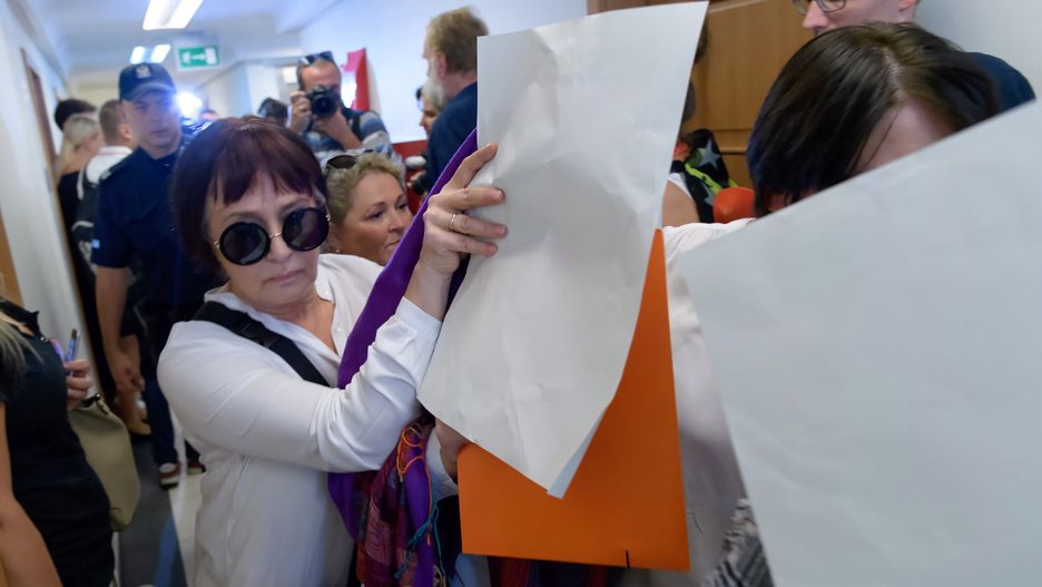 Osoby prowadzą na salę rozpraw poszkodowaną podczas procesu w Sądzie Apelacyjnym w Poznaniu.