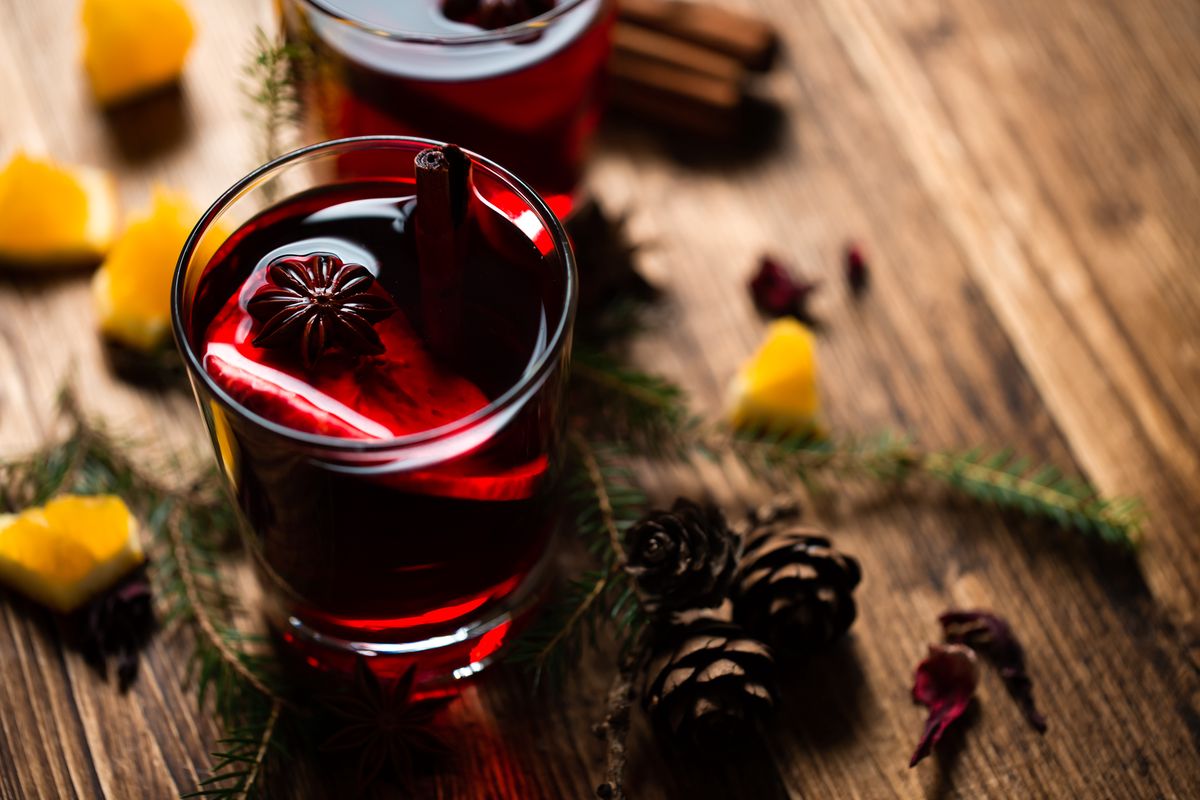 Christmas mulled wine in clear glasses and scattered around spices and lemon slices