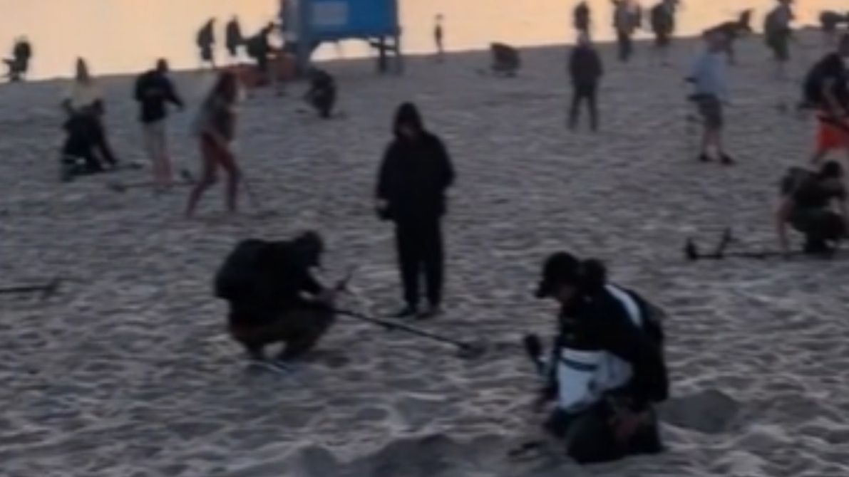 Ludzie z wykrywaczami metali na plaży