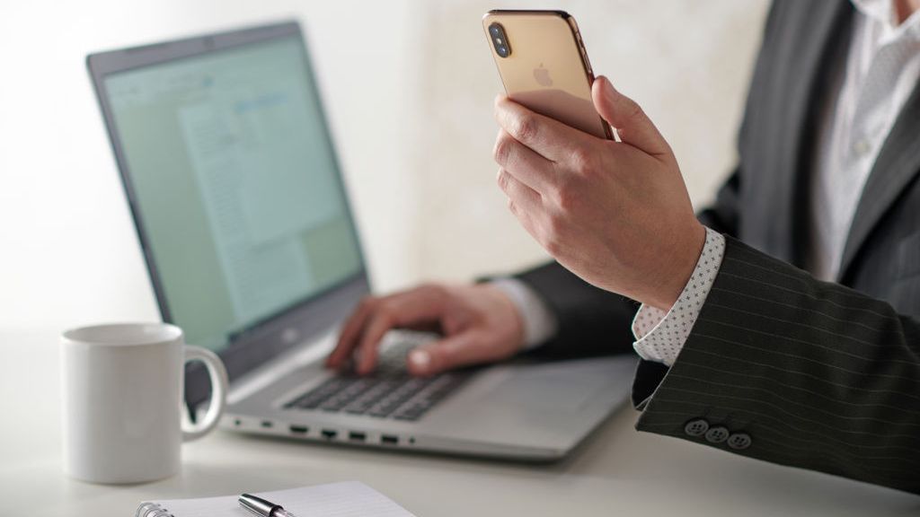 Businessman Using Smartphone And Laptop
Close up detail of a businessman working at a desk with a smartphone and laptop computer, taken on January 31, 2019. (Photo by Neil Godwin/Future via Getty Images)
Future Publishing
Colour Image, Color Image, Horizontal, Photography, Indoors, Adults Only, One Person, People, Male, Men, One Man Only, Mid Section, Part Of, Hand, Human Hand, Sitting, Typing, Formal Clothing, Businesswear, Button Down Shirt, White Shirt, Suit Jacket, Smart Casual, Technology, Wireless Technology, Hardware, Computer, Laptop, Using Laptop, Dell Inspiron, Accessibility, Portability, Communication, Phone, Mobile Phone, Portable Information Device, Smart Phone, Smartphone, Telephone, Apple iPhone XS, Messaging, The Internet, Mug, Cup, Hot Drink, Coffee, Notebook, Notepad, Pen, Desk, Business, Occupation, Professional, Work, Working, Business Finance and Industry, Place Of Work, Productivity, Lifestyles, Copy Space, Business Person, Businessman