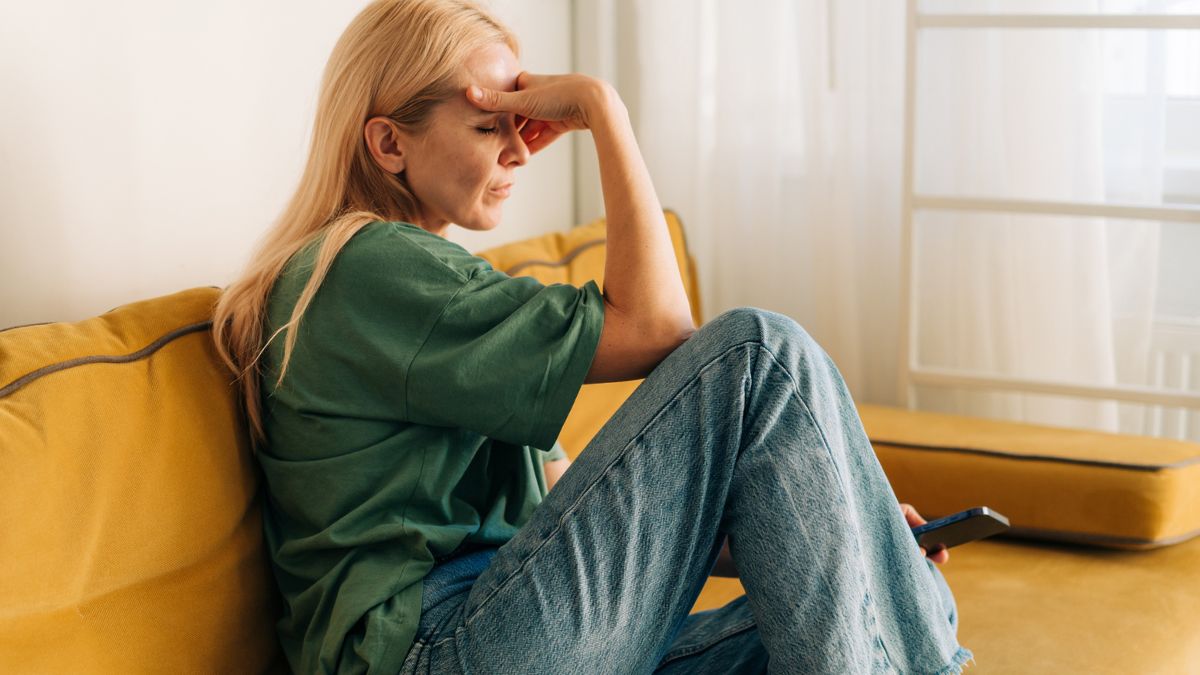 Smutna kobieta siedzi na kanapie