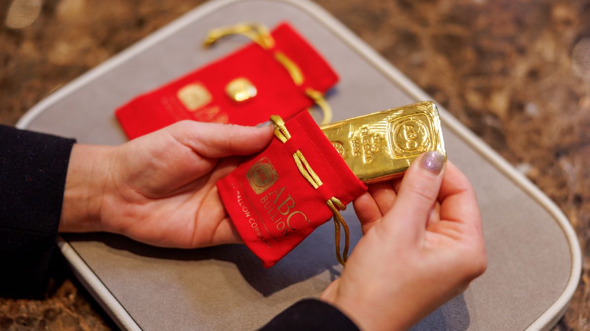 A shop assistant places a 500 gram gold bar in a protective pouch at an ABC Bullion store in Sydney, Australia, on Tuesday, Oct. 21, 2025. Gold held near a record high, finding support despite optimism global trade tensions are easing and hopes the US government will reopen soon. Photographer: Brendon Thorne/Bloomberg via Getty Images