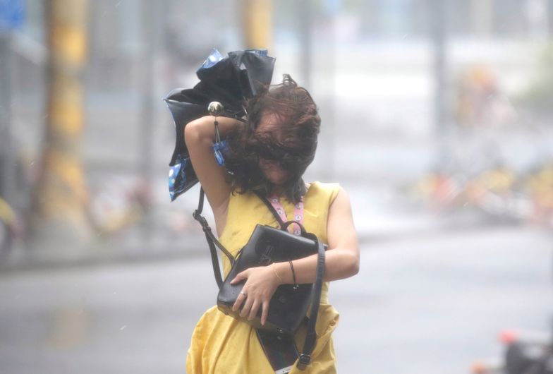 Kobieta na ulicy jednego z chińskich miast, w które uderzył tajfun