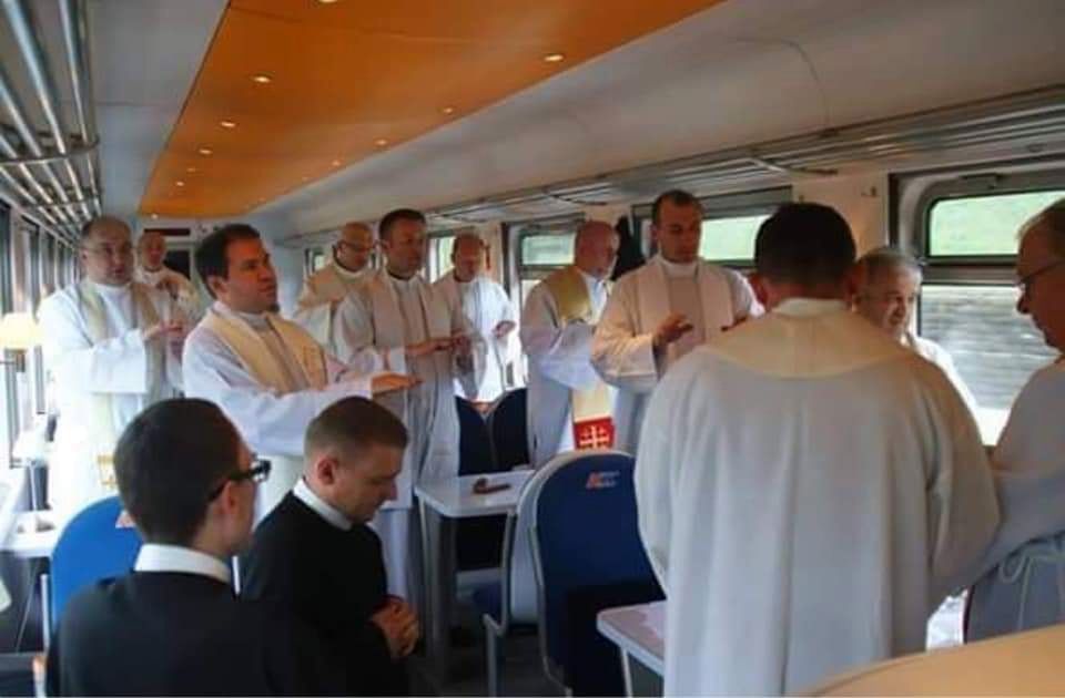 Na jednym ze zdjęć widać, jak kilkunastu księży odprawia mszę świętą w wagonie restauracyjnym.