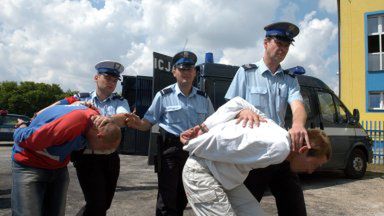 Policjanci prowadzą do sądu w Łowiczu dwóch bandytów