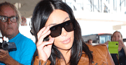 Ciężarna Kim Kardashian w bardzo obcisłej sukience na lotnisku [PAPARAZZI]
