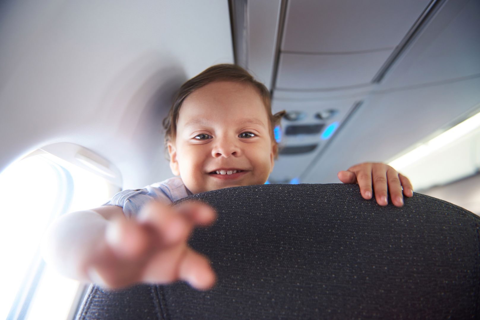 Smiling little boy travel  in airlane. Child air plane passenger