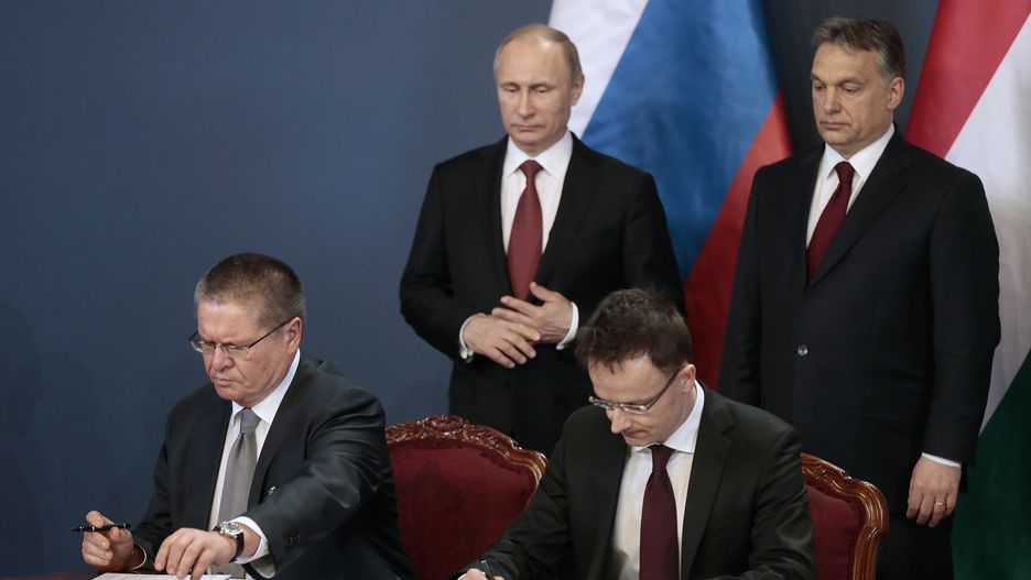 Minister Rozwoju Gospodarczego FR Aleksiej Uliukajew (lewy dół) i Minister Spraw Zagranicznych Węgier Peter Szijjarto (prawy dół) podpisują dokumenty. W tle prezydent Rosji Władimir Putin (lewy góra) i premier Węgier Wiktor Orban (prawy góra).