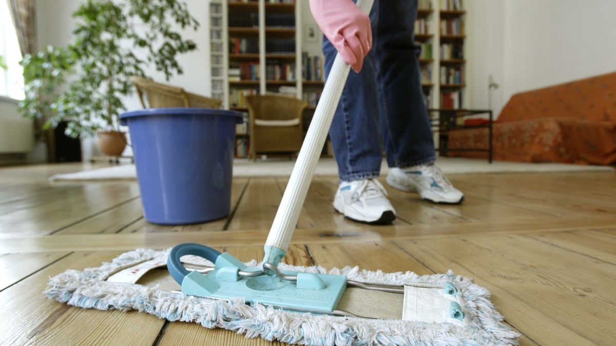 Putzen, Boden wischen(GERMANY OUT) Deutschland, Symbol, Haushaltshilfe, Putzfrau, Hausfrau, Frau wischt in einer Wohnung den Fussboden mit einem Wischmob (Photo by Schicke/ullstein bild via Getty Images)ullstein bild