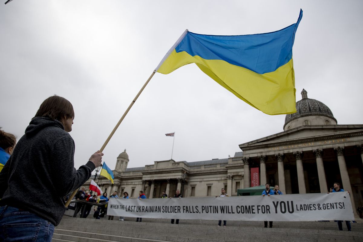 LONDON, UNITED KINGDOM - 2022/04/02: A demonstrator is seen waving a Ukrainian flag in front of the National Portrait Gallery at Trafalgar Square during the rally. Demonstrations in support of Ukraine have been ongoing on a daily basis in London since the Russia-Ukraine War started on 24th February 2022. Participants demand NATO to close the air space above Ukraine to stop Russia from bombing the country and send arms to support Ukrainian army. (Photo by Hesther Ng/SOPA Images/LightRocket via Getty Images)