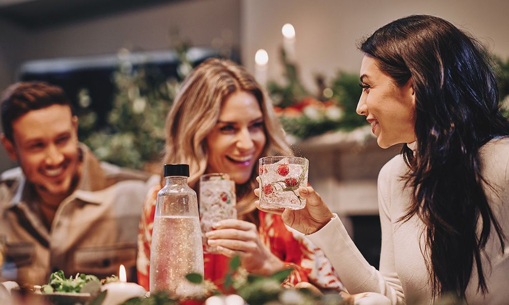 Grupa przyjaciół przy stole z napojami w rękach. - zdjęcie