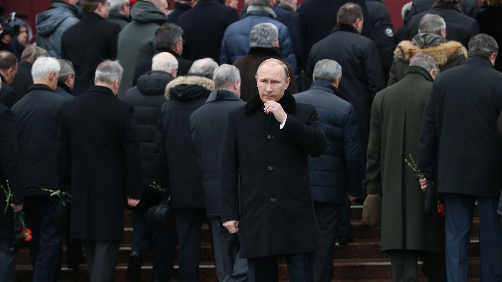 Na zdjęciu Władimir Putin. Za nim odwrócni ludzie do niego plecami