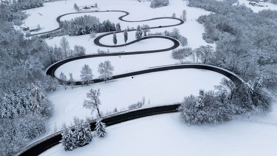 Izdebki, 23.11.2025. Na zdjęciu z drona serpentyny na drodze powiatowej numer 2061R w miejscowości Izdebki, 23 bm. Po intensywnych opadach śniegu nawierzchnie większości tras na Podkarpaciu są zazwyczaj czarne, ale na wielu odcinkach leży błoto pośniegowe. (dd/amb) PAP/Darek Delmanowicz