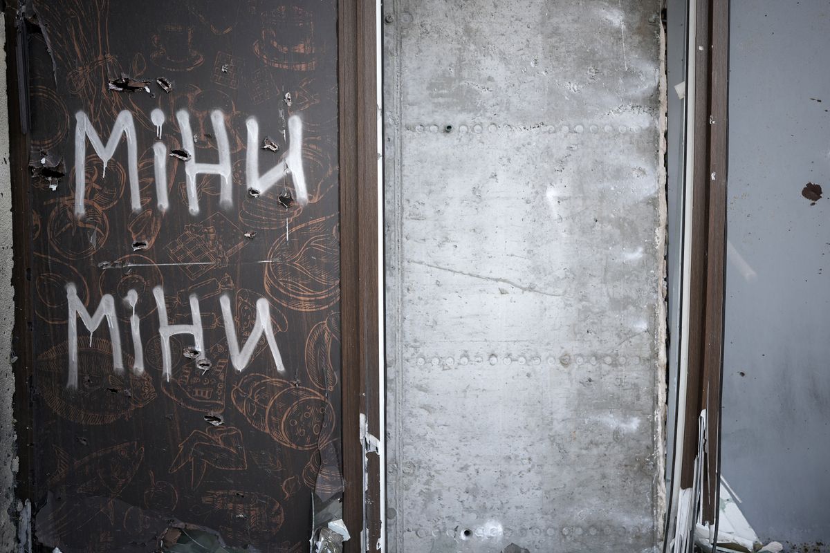 IRPIN, UKRAINE - MAY 26: A spray painted sign warns of possible mines on a shop door on May 26, 2022 in Irpin, Ukraine. As Russia concentrates its attack on the east and south of the country, residents of the Kyiv region are returning to assess the war's toll on their communities. The towns around the capital were heavily damaged following weeks of brutal war as Russia made its failed bid to take Kyiv.  (Photo by Christopher Furlong/Getty Images)
