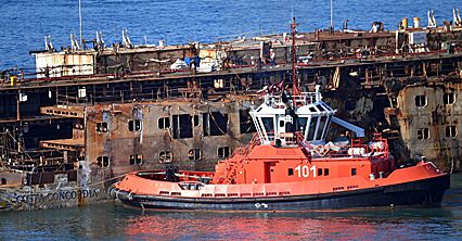 Wrak statku Costa Concordia holowany do portu w Genui