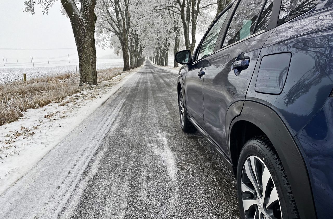 Black ice can be covered by a delicate layer of snow. It is especially slippery on narrow roads with trees on the roadside.