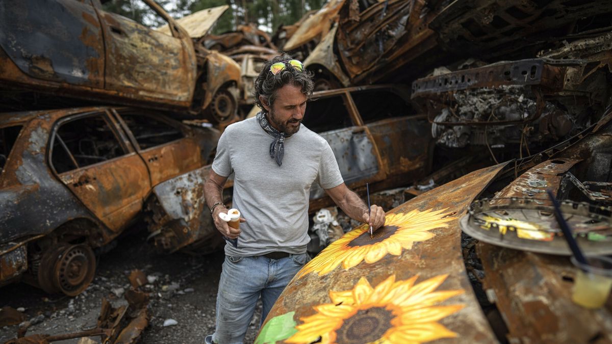 Artyści malują "kwiaty nadziei" na wrakach pojazdów w Ukrainie.
