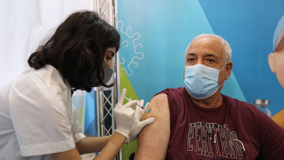 Israel offers third Covid-19 vaccine doses epa09409494 A nurse injects a man with a third shot of COVID-19 vaccine in Jerusalem, Israel, 11 August 2021. Israel launched a campaign to offer a third Covid-19 vaccine dose for people over 60 who received a second shot at least five months ago after infections were reportedly increasing in the country. According to reports, the number of infections in Israel rose above 6,000 per day.  EPA/ABIR SULTAN  Dostawca: PAP/EPA. ABIR SULTAN