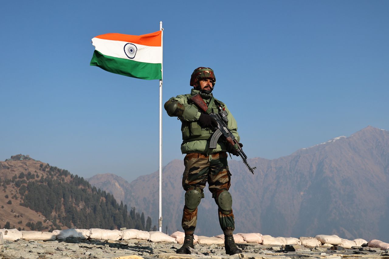 An army soldier is standing alert near the Indian National Flag (Tri-Color) at the Line of Control (LoC) between Pakistan and India in the Uri Sector, Jammu and Kashmir, India, on January 24, 2024. 'Operation Sard Hawa' is underway, with a 15-day alert along the Indo-Pak border in anticipation of Republic Day. The Border Security Forces (BSF) are on a special alert along the India-Pakistan border in four states, including Jammu and Kashmir. (Photo by Nasir Kachroo/NurPhoto via Getty Images)