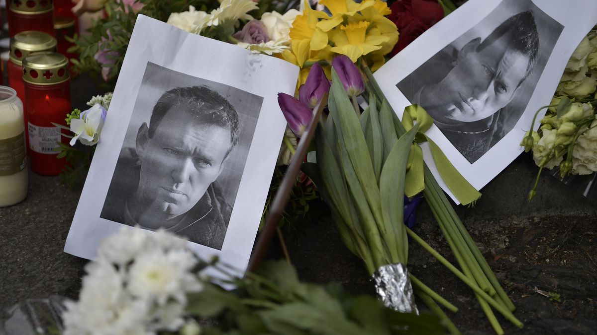 BUCHAREST, ROMANIA - FEBRUARY 18: People hold banners as they place lit candles next to a poster of Russian opposition figure Alexey Navalny, outside the Russian embassy in Bucharest, Romania, Sunday, February 18, 2024. (Photo by Alex Nicodim/Anadolu via Getty Images)