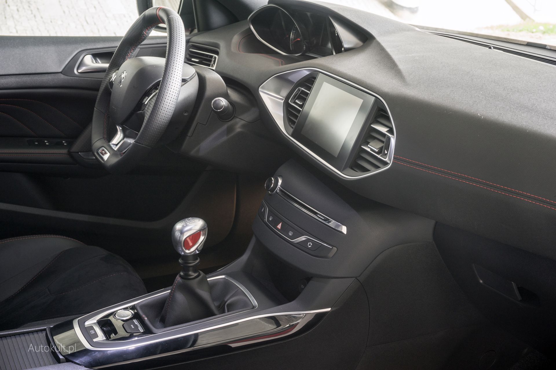 Minimalistyczne wnętrze 308 mimo upływu lat nadal wygląda świetnie, a czerwone akcenty GTI podkreślają jego sportowy charakter.