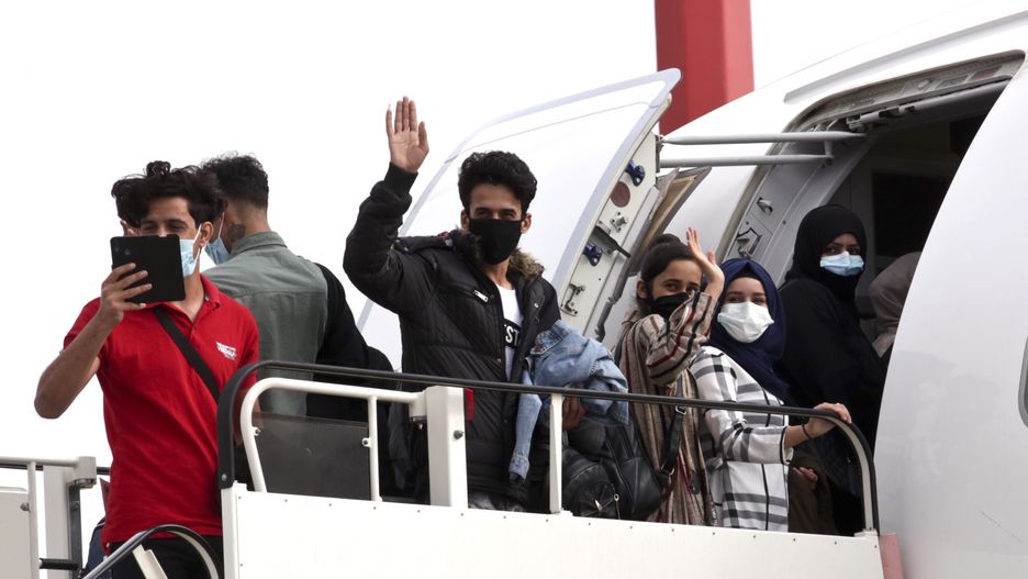 ATHENS, GREECE - MAY 11: A group of 50 people, including 16 asylum-seeking minors and 34 migrants from overcrowded migrant camps, many wearing protective face masks, board a plane from Athens International Airport to the UK on May 11, 2020 in Athens, Greece. The 50 left today to the UK where they will reunite with their families.  (Photo by Milos Bicanski/Getty Images)