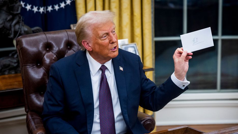 US President Donald Trump looks at a letter left for him by former President Joe Biden, not pictured, while signing executive orders in the Oval Office of the White House in Washington, DC, US, on Monday, Jan. 20, 2025. President Donald Trump launched his second term with a strident inaugural address that vowed to prioritize Americas interests with a "golden age" for the country, while taking on "a radical and corrupt establishment." Photographer: Jim Lo Scalzo/EPA/Bloomberg via Getty Images