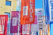 Flagi z logotypami kanałów obok głównej siedziby TVP