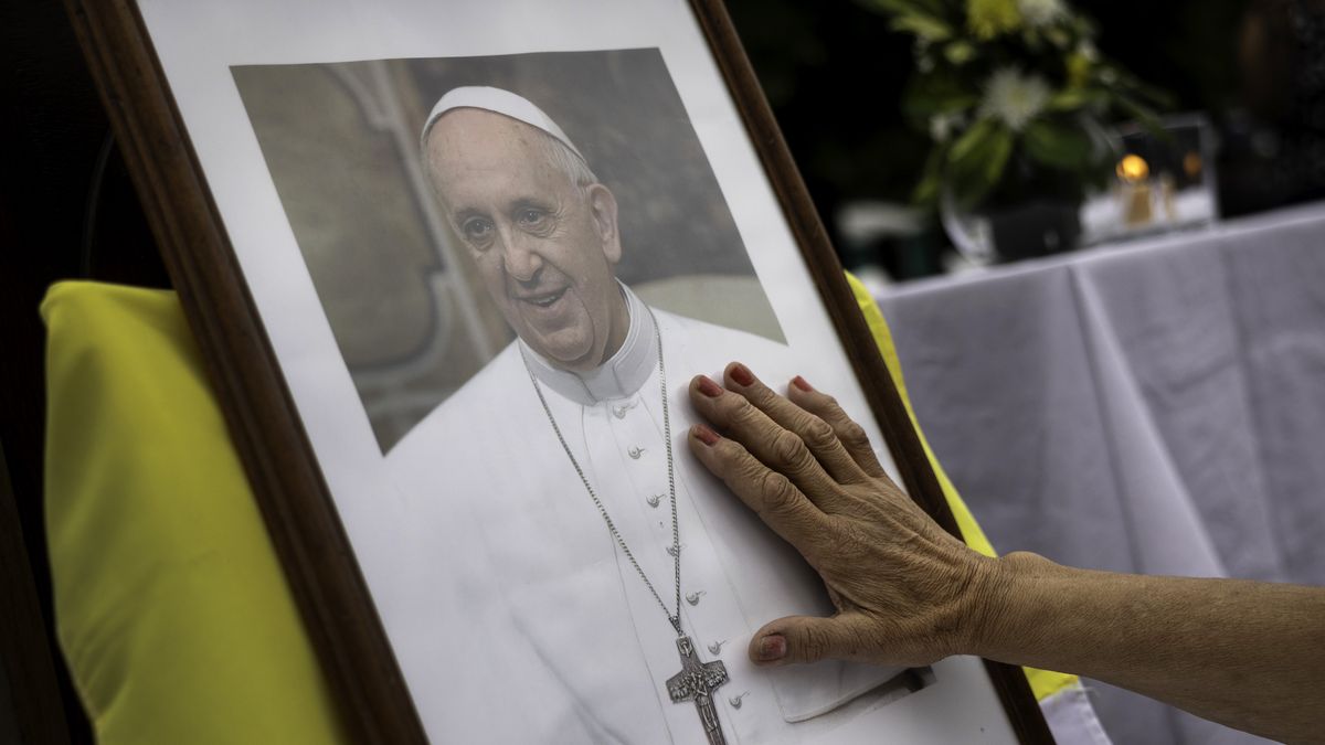 BUENOS AIRES, ARGENTINA - FEBRUARY 24: A woman touches a portrait of Pope Francis following a Catholic Mass held to pray for the ailing Pontiff on February 24, 2025 in Buenos Aires, Argentina. Born in Buenos Aires and the first Pope ever chosen from the Americas, Pope Francis was hospitalized in Rome on February 14 with bronchitis, and was subsequently treated for a respiratory tract infection. The Vatican confirmed on Monday that the pope is still in critical condition but he could sleep, wake up and eat. (Photo by John Moore/Getty Images)