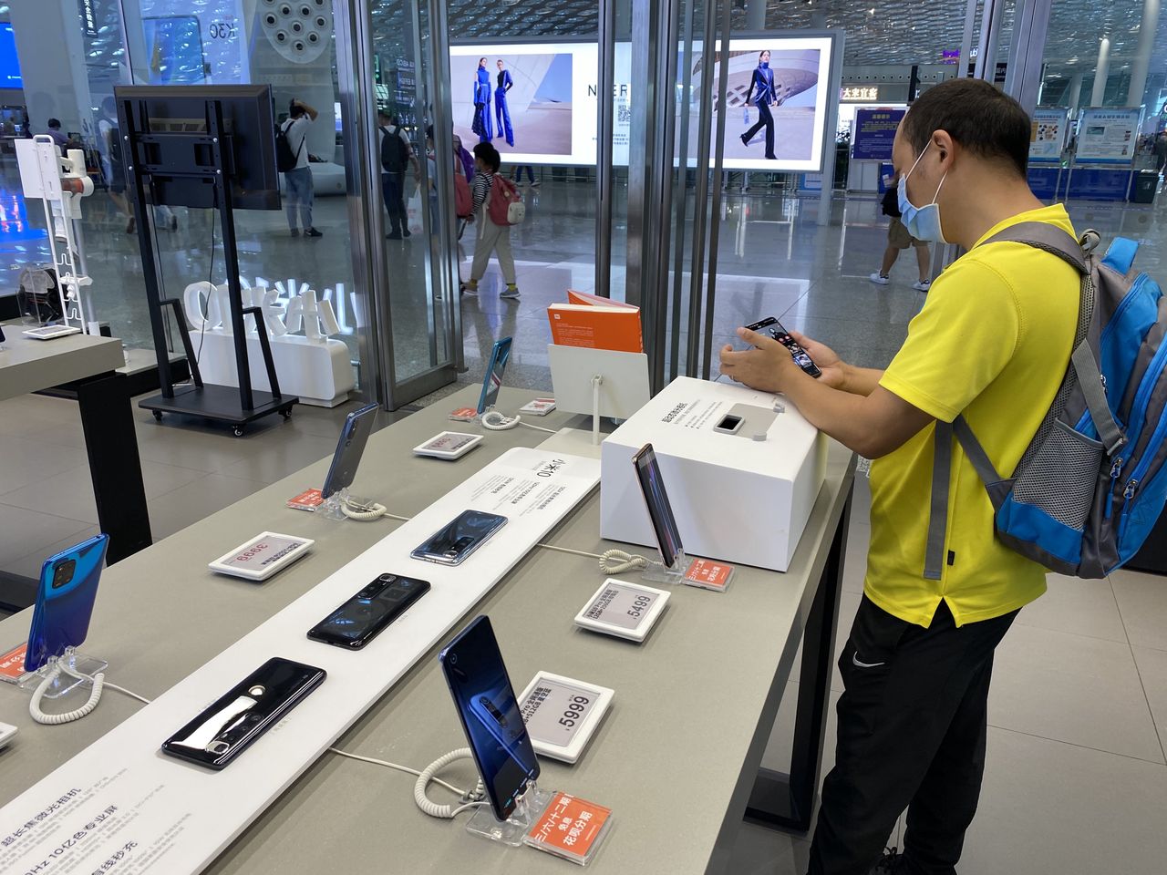 SHENZHEN - AUGUST 14: A man looks at Xiaomi smartphones at a Xiaomi experience store on August 14, 2020 in Shenzhen, Guangdong Province of China. (Photo by VCG/VCG via Getty Images)