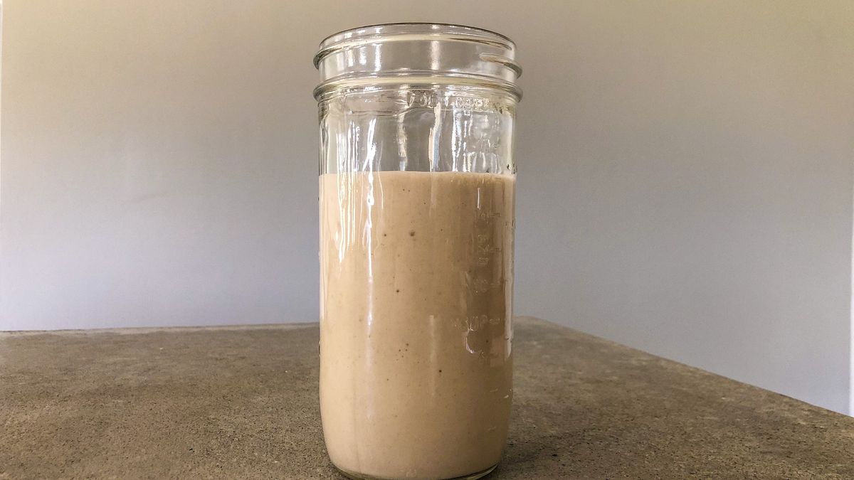 Sourdough bread starter in glass jar, sitting on a concrete countertop.
A jar of sourdough starter sitting on a concrete countertop.
Alex Lane