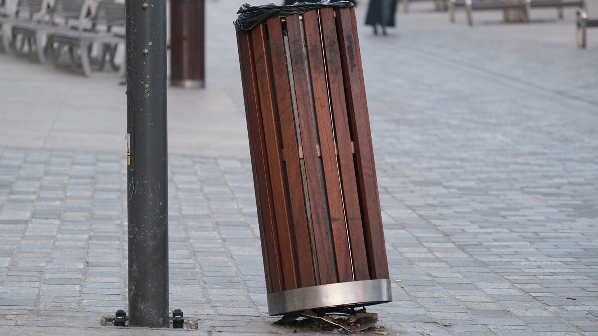 Uszkodzony kosz na odpady na deptaku