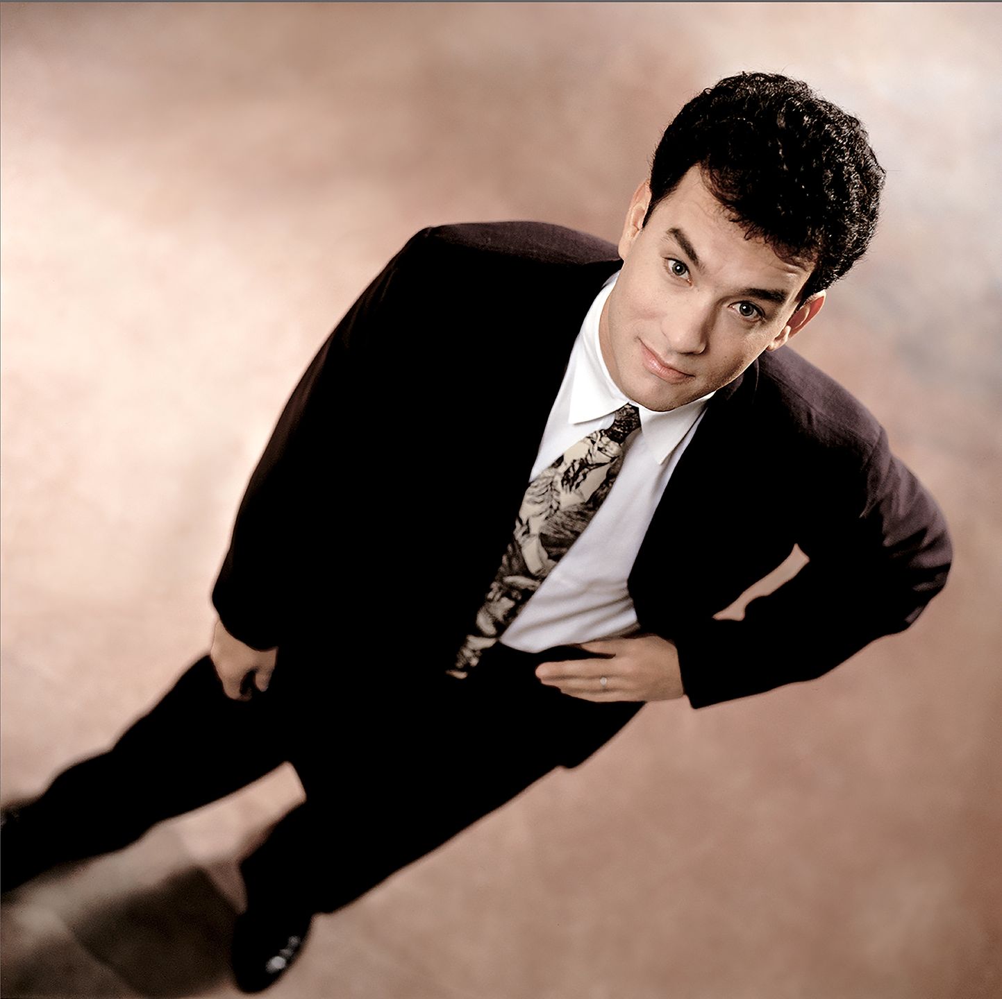Actor Tom Hanks looks up at the camera in a suit in Los Angeles in 1980. (Photo by Bonnie Schiffman/Getty Images)