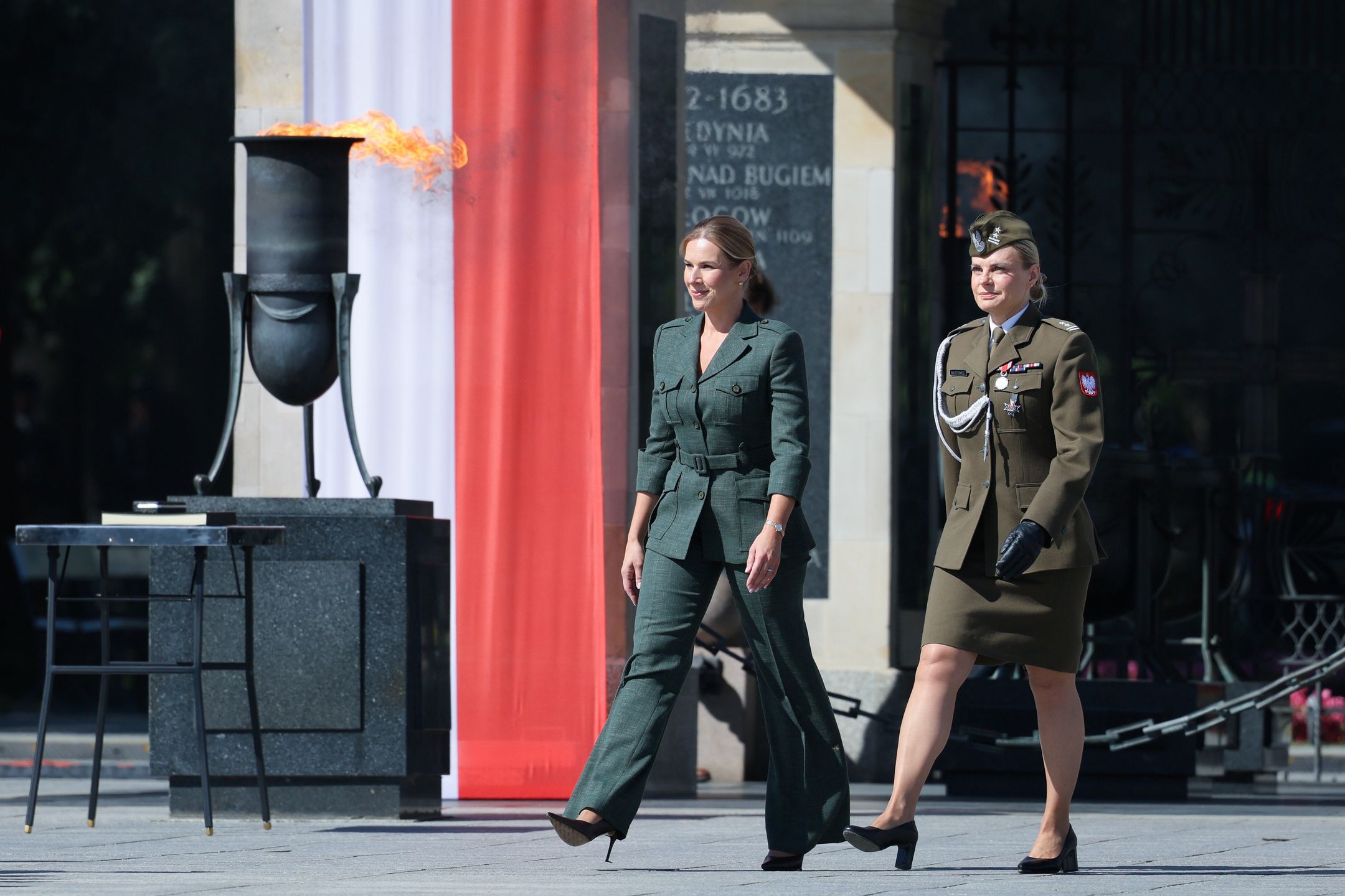 Warszawa, 15.08.2026. Pierwsza dama Marta Nawrocka (L) i ppłk Dorota Bołotowicz (L) w drodze na uroczystą Zmianę Posterunku Honorowego przed Grobem Nieznanego Żołnierza w Warszawie, 15 bm. Trwają obchody Święta Wojska Polskiego, które w tym roku odbywają się pod hasłem ?Polska SAFE - bezpieczna Polska?. (sko) PAP/Paweł Supernak