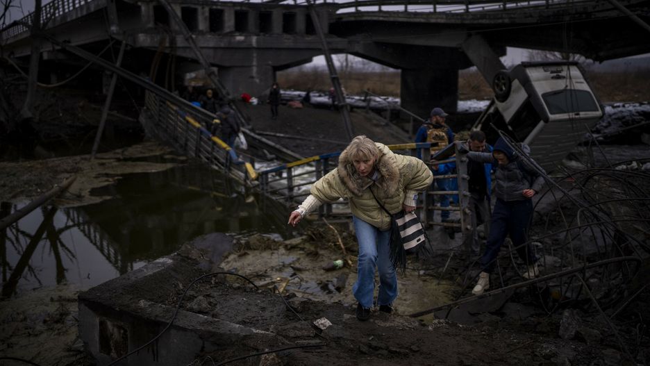 Wojna w Ukrainie - sytuacja ludno?ci cywilnejA woman runs as she flees with her family across a destroyed bridge in the outskirts of Kyiv, Ukraine, Wednesday, March 2. 2022. Russia renewed its assault Wednesday on Ukraine???s second-largest city in a pounding that lit up the skyline with balls of fire over populated areas, even as both sides said they were ready to resume talks aimed at stopping the new devastating war in Europe. (AP Photo/Emilio Morenatti)AP