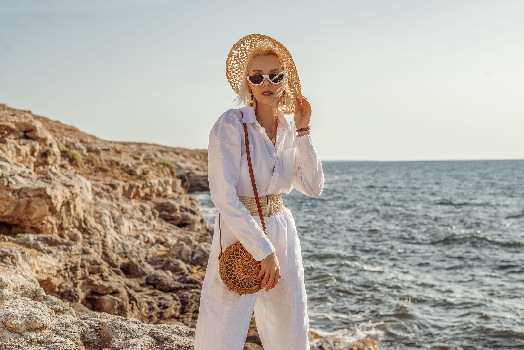 summer, fashion, linen, woman, suit, white, sea, bag, round, wicker, sunglasses, trend, luxury, elegant, wear, posing, style, vacation, purse, look, lady, model, girl, outfit, outdoor, clothes, accessories, glasses, specs, dressed, nature, hat, belt, raffia, straw, rocks, outside, eyeglasses, spectacles, summertime, trip, travel, beautiful, young, female, sunny, natural, rotan, confident, advertising