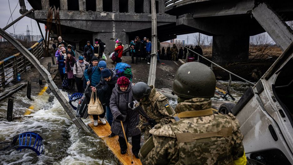 Wojna w Ukraine - Sytuacja w IrpieniuEvacuees cross a destroyed bridge as they flee the city of Irpin, northwest of Kyiv, on March 7, 2022. - Ukraine dismissed Moscow's offer to set up humanitarian corridors from several bombarded cities on Monday after it emerged some routes would lead refugees into Russia or Belarus. The Russian proposal of safe passage from Kharkiv, Kyiv, Mariupol and Sumy had come after terrified Ukrainian civilians came under fire in previous ceasefire attempts. (Photo by Dimitar DILKOFF / AFP)DIMITAR DILKOFF