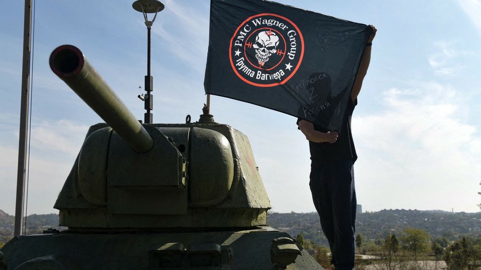 Mężczyzna na czołgu z flagą Grupy Wagnera. Zdjęcie ilustracyjne