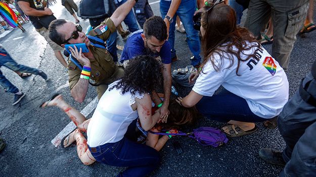 Uczestnicy parady pomagają dziewczynie ranionej przez nożownika