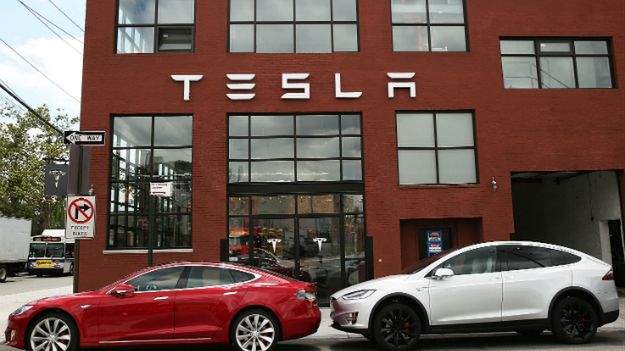 Samochody marki Tesla zaparkowane przez salonem i serwisem w Nowym Jorku.