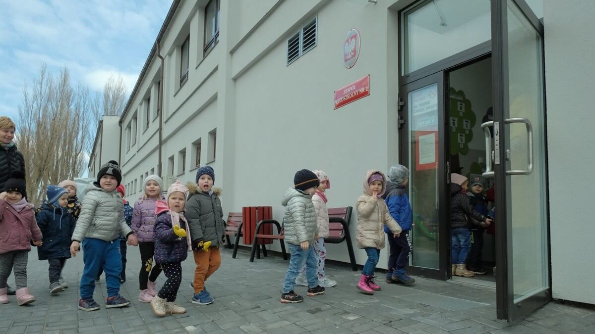 Dzieci wchodzące do budynku przedszkola przy ul. Farbiarskiej