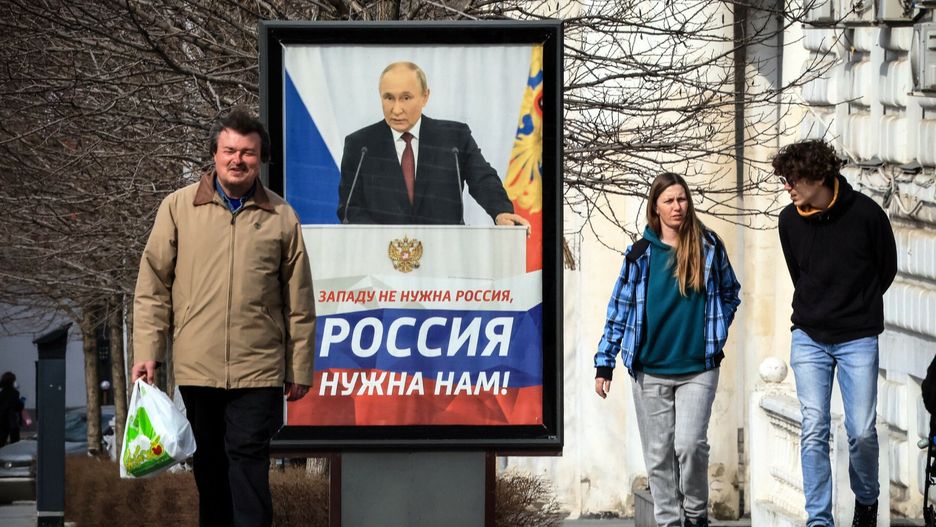 Symferopol na Krymie. Ludzie idą przed plakatem z Putinem