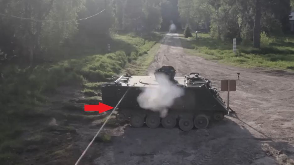 Rosjanie strzelający do transportera opancerzonego M113 z armaty kal. 30 mm, gdzie jeden z dwóch pocisków chybia i przelatuje nad celem.