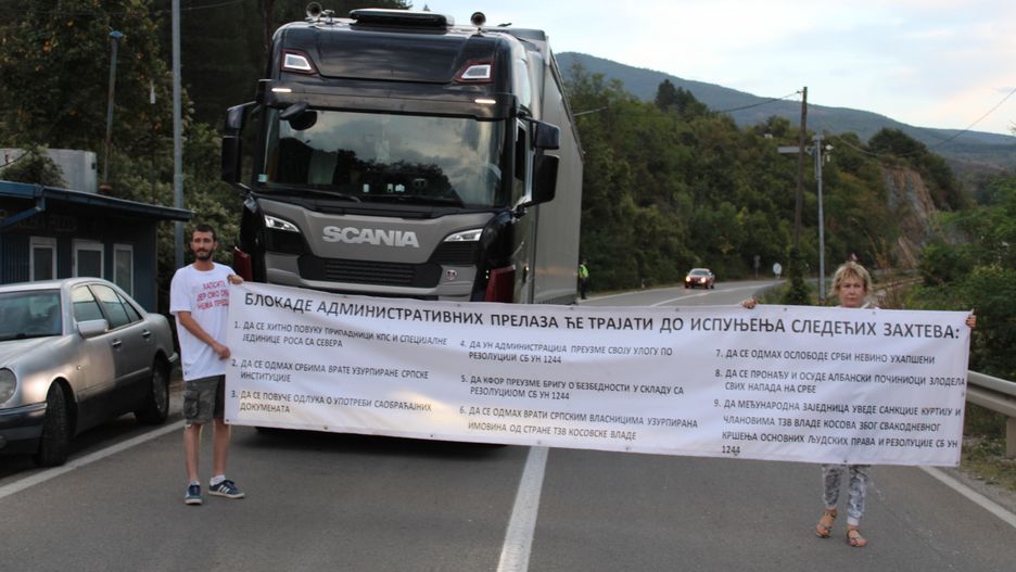 RUDNICA, SERBIA - SEPTEMBER 6: Protesters who began a protest and partial blockade at the Jarinje border crossing between Serbia and Kosovo carry a banner outlining nine demands, which include the withdrawal of Kosovo police from northern Kosovo and the reopening of Serbian institutions that had been shut down in the region in Rudnica, Serbia on September 06, 2024. The demonstration, announced in advance, saw a small group of citizens, representing local associations, block the road between Rudnica and Jarinje. The demonstrators are allowing emergency vehicles and cars with Serbian license plates to pass through. However, they have stated that vehicles and citizens of Kosovo with documents issued by Pristina will not be permitted to cross. (Photo by Aleksandar Niciforovic/Anadolu via Getty Images)