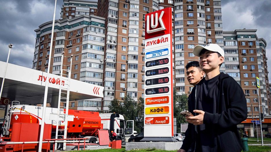 Ludzie przechodząc obok stacji benzynowej w Moskwie