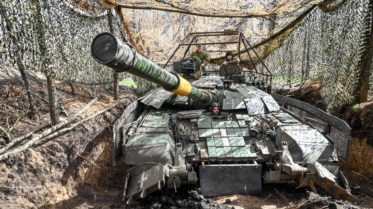 Ukraińscy żołnierze w czołgu, ukrytym pod siatką maskującą, marzec 2024 roku