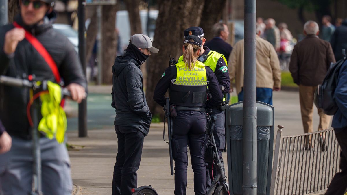 SEVILLE ANDALUSIA,, SPAIN - FEBRUARY 25: Agents of the Seville Local Police inform an electric scooter user of the entry into force of the regulations governing its use. On 25 February 2026, in Seville (Andalusia, Spain). The reform of the Seville City Council regulations governing the use and circulation of personal mobility vehicles (PMVs), specifically "scooters", comes into force this Wednesday after publication on Tuesday in the Official Provincial Gazette (BOP). Among the most particular modifications that affect the user are the prohibition of parking on pavements and pedestrian areas, as well as anchoring it to elements of street furniture or trees, among others, since parking can only be carried out in the spaces provided for this purpose. It is also important to note the obligation to wear a reflective waistcoat and an approved protective helmet. (Photo By Francisco J. Olmo/Europa Press via Getty Images)